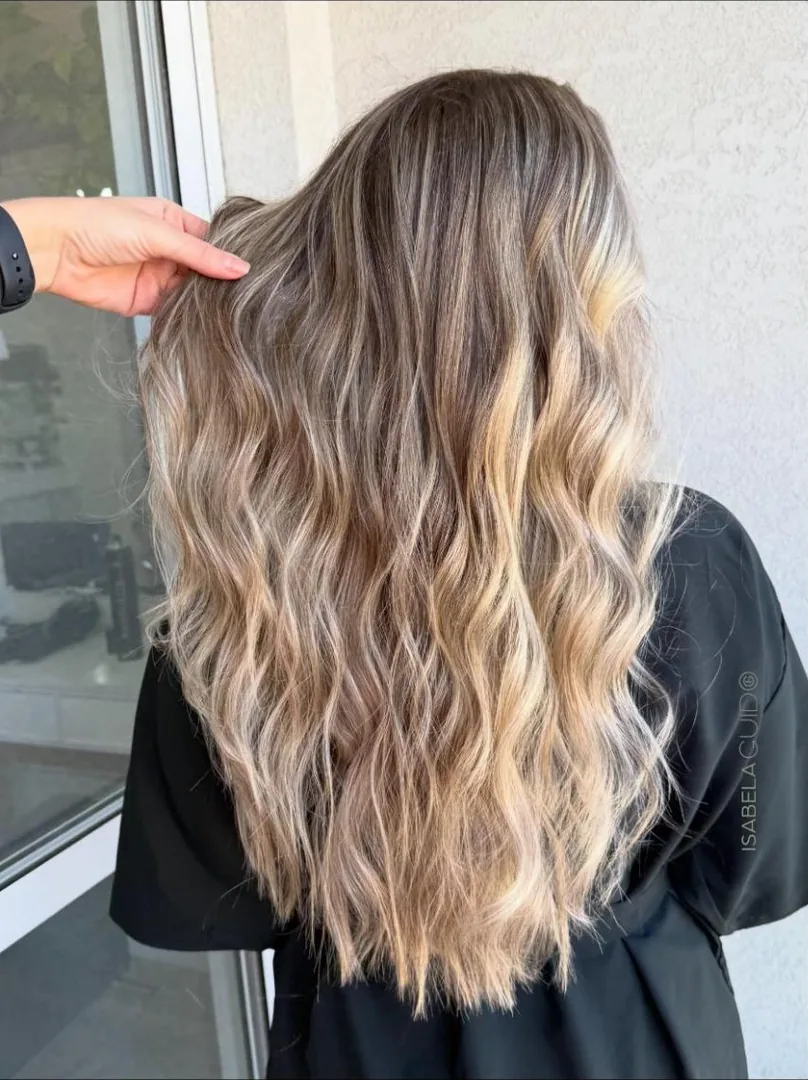 Cabelo longo loiro com mechas e ondas, visto de costas